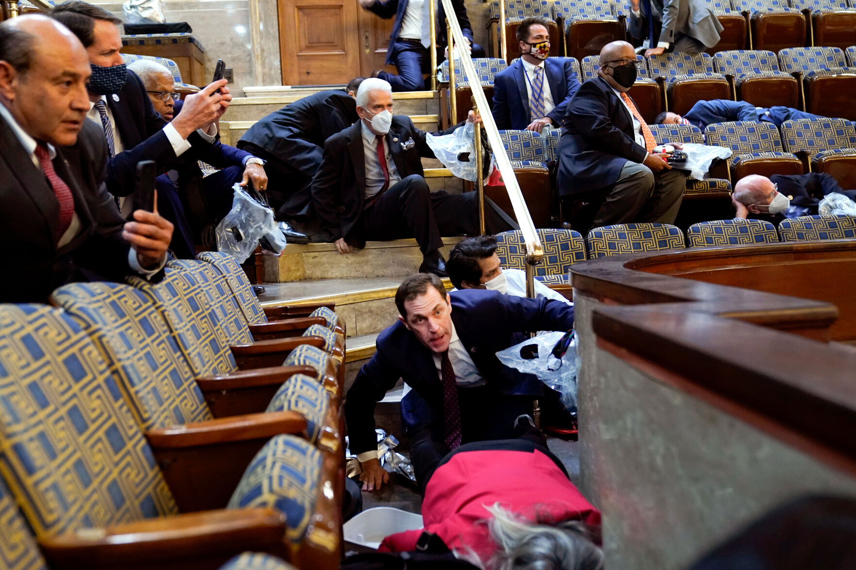 People shelter in the House gallery as rioters try to break into the House Chamber